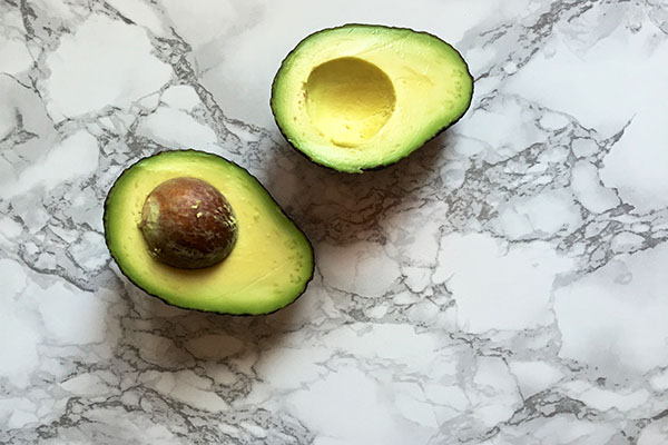 Split open avocado on marble