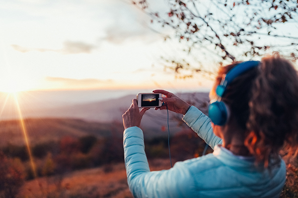 Woman taking photo of a sunset