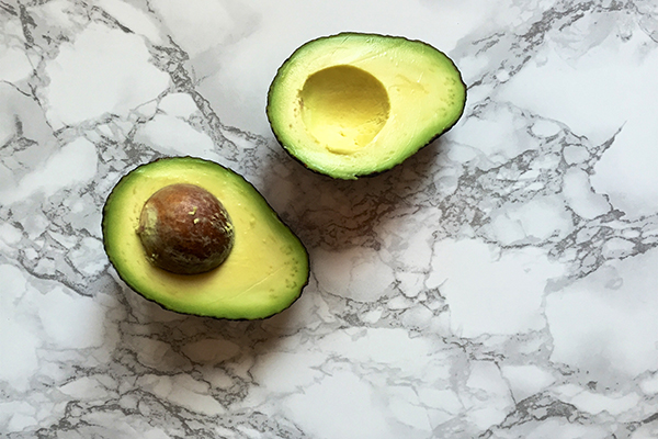 Split avocado on marble