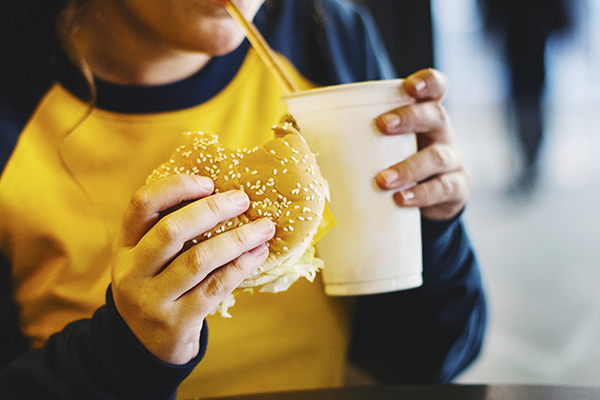 Woman eating burger and soda