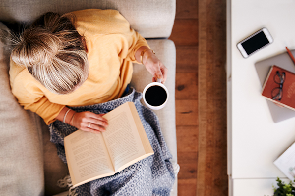 Woman reading a book on a sofa