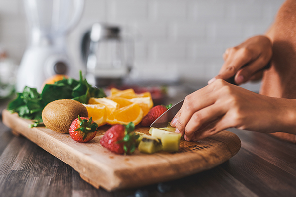 woman cutting fresh fruits