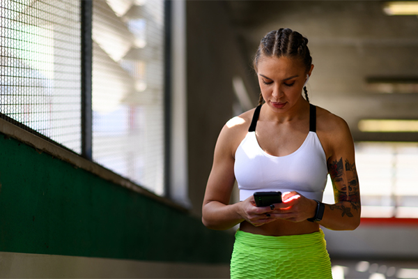 fitness woman looking at phone | Running Motivation