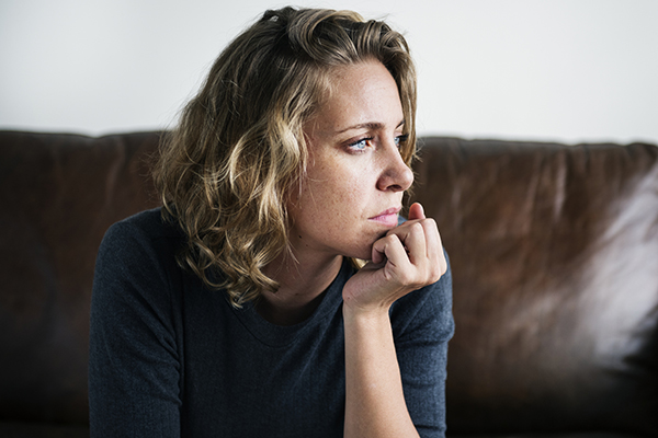 Anxious woman looking out window