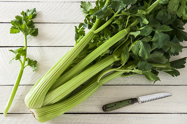 Green celery on the white wooden table