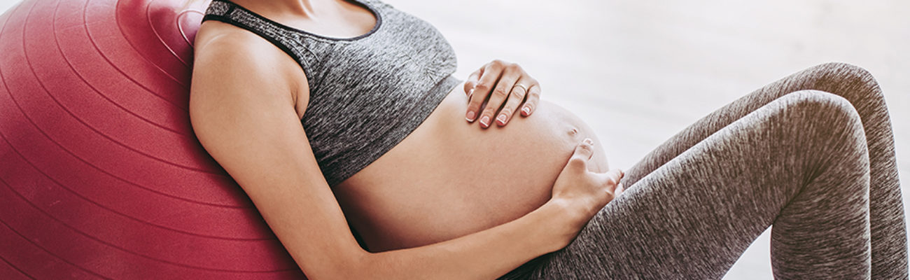 Pregnant woman doing birthing ball exercises