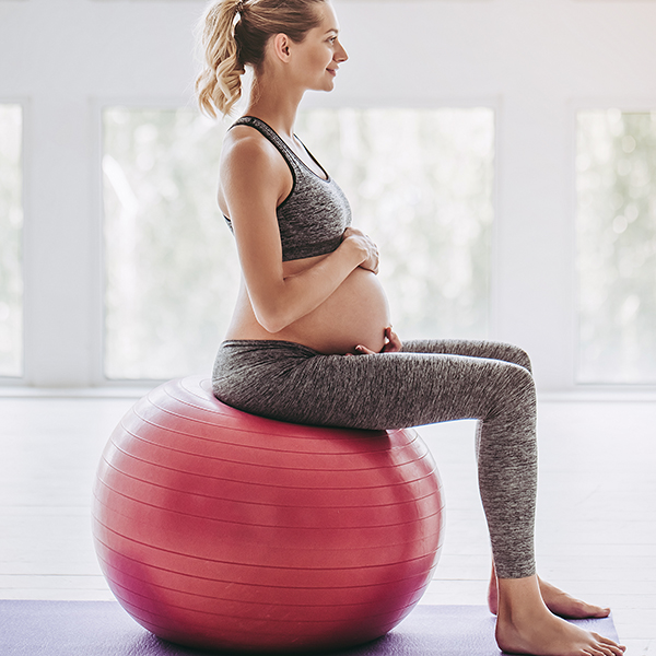 Pregnant woman doing birthing ball exercises