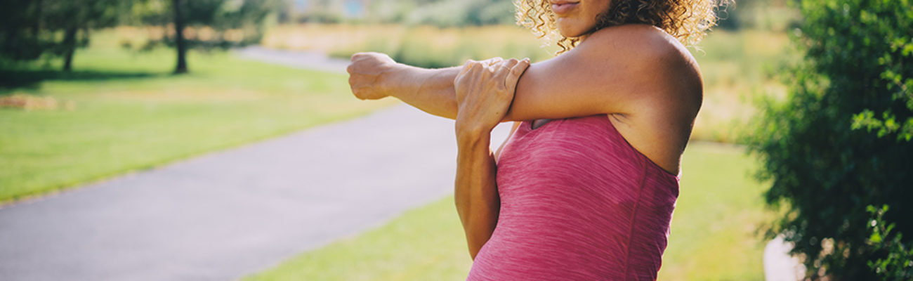 A pregnant woman walking in a park.