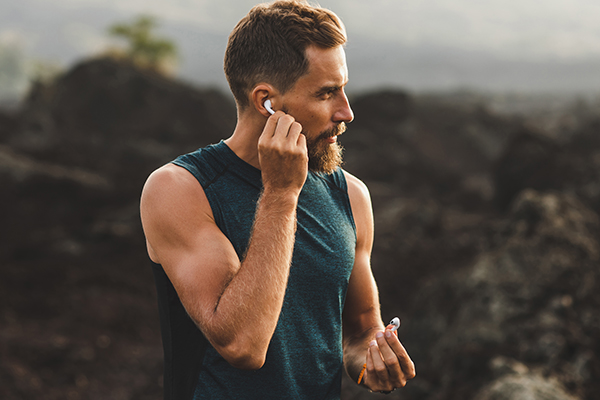 Man using wireless earphones air pods on running outdoors. 