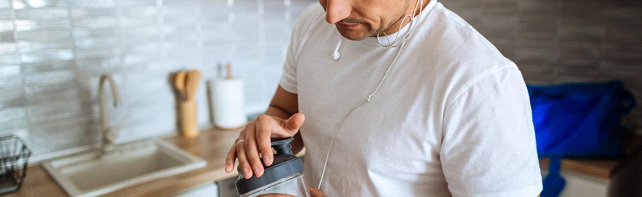 Man making protein shake before workout