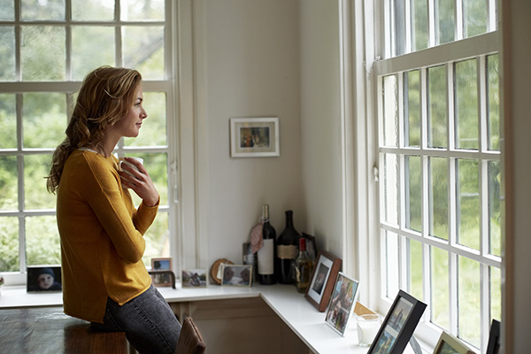 Woman looking out a window thoughtfully