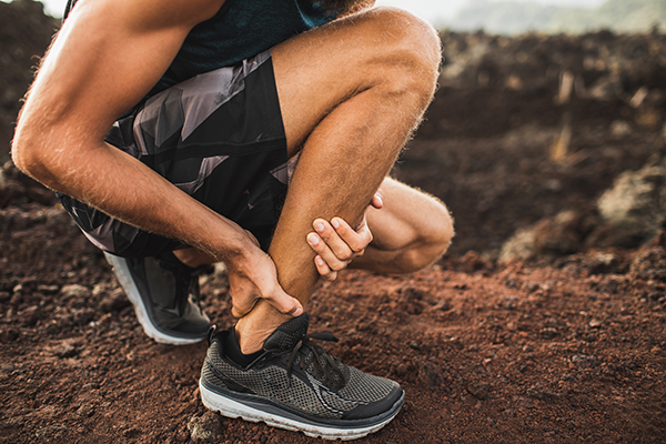 Man grabbing Achilles tendon