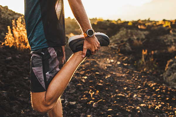 Male runner stretching his leg