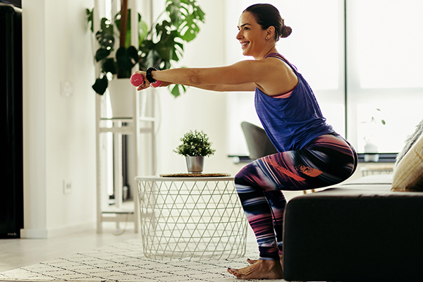 Woman exercising at home doing lunges exercise. 