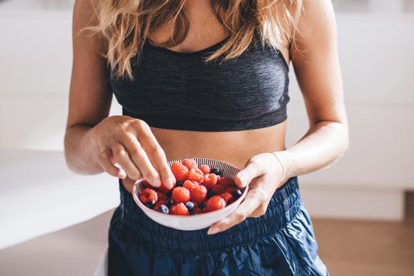 Woman eating a bowl of berries