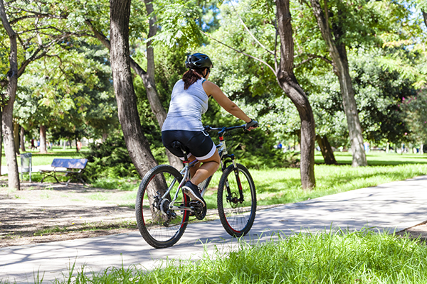 Woman biking through a park