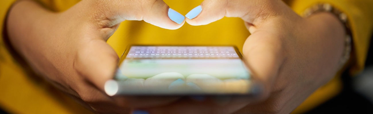 Young woman typing text message on cellphone