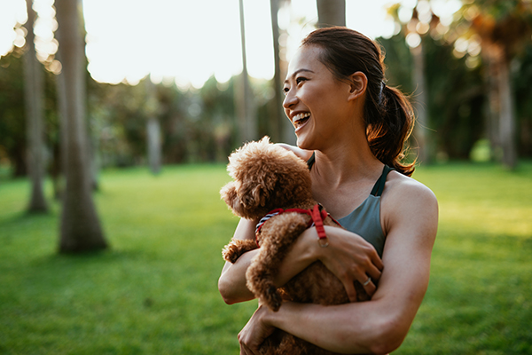 Woman holding dog, laughing