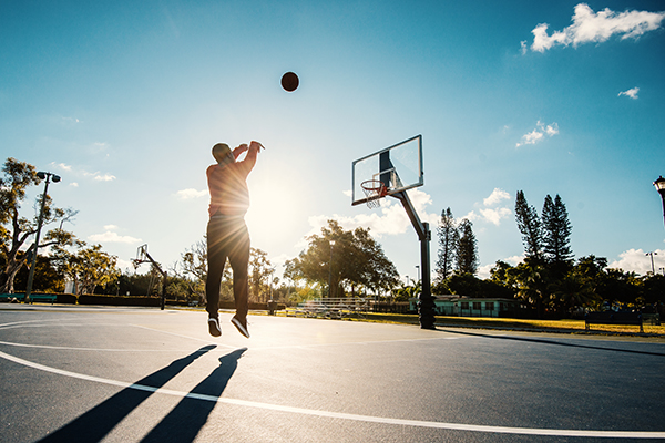 Man shooting basketball hoops outside