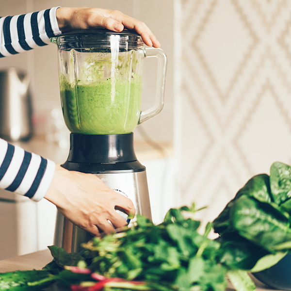 Woman making a green smoothie