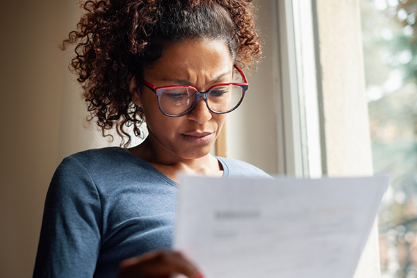 Worried woman looking at piece of paper