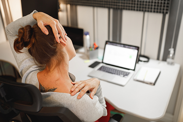 Woman stretching her neck while working at home