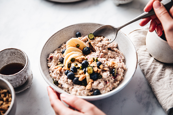 Woman eating oatmeal with fruit