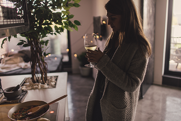 Woman drinking wine at home alone