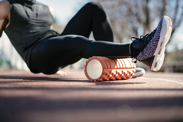 Man using foam roller to massage calf