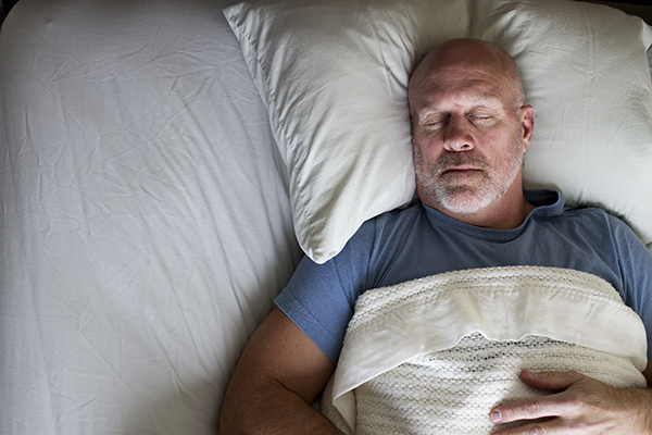 Older man sleeping on his back