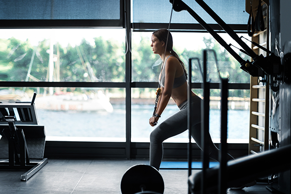 Woman using cable pulley machine at a gym