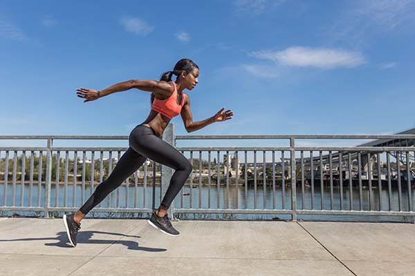 Woman athlete sprinting outside