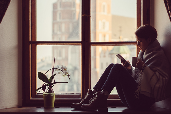 Woman sitting near window, texting