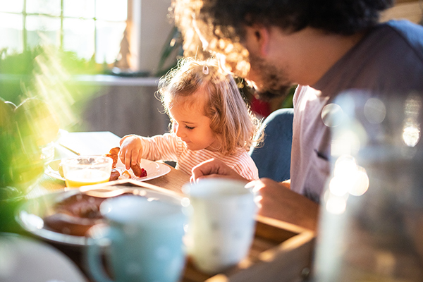 father and daughter eating breakfast