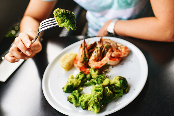 Woman eating broccoli