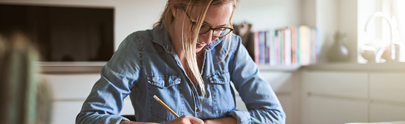 Woman writing in a journal at home