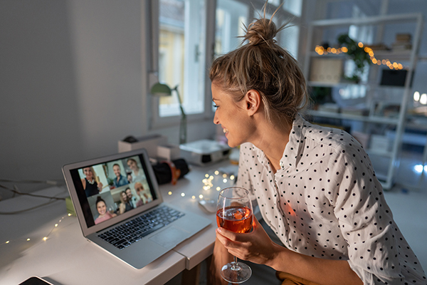 Woman drinking wine on virtual happy hour call