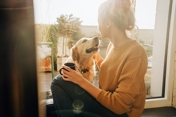 Woman having coffee alone with dog