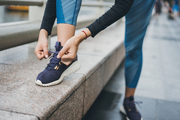 Female runner tying her shoe