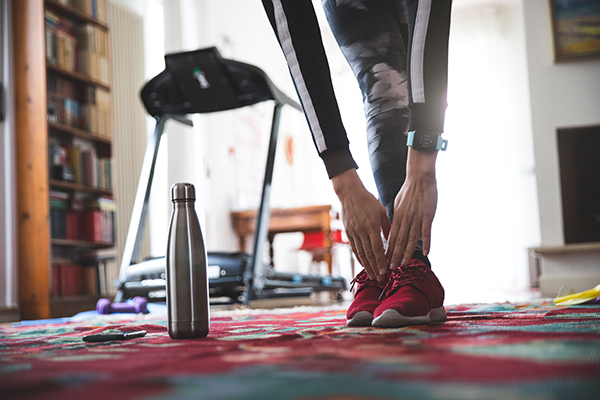 Woman stretching her hamstrings at home