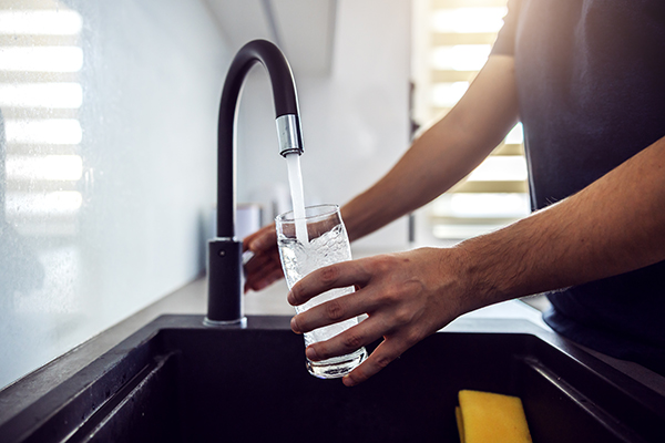 Man filling glass with tap water