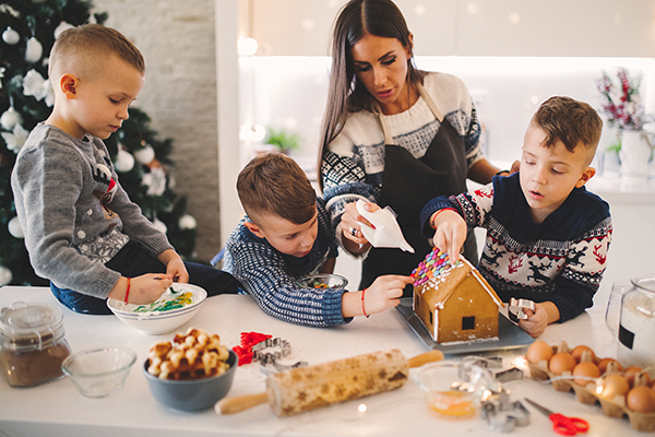 Mom and sons making gingerbread house