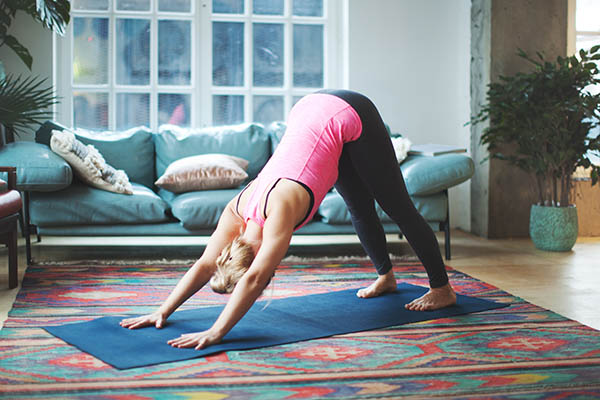 Woman doing downward dog pose at home