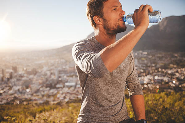Man drinking water outside