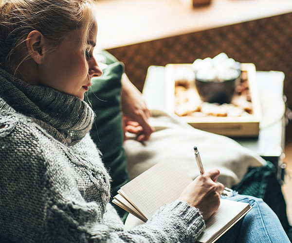 Woman writing in gratitude journal