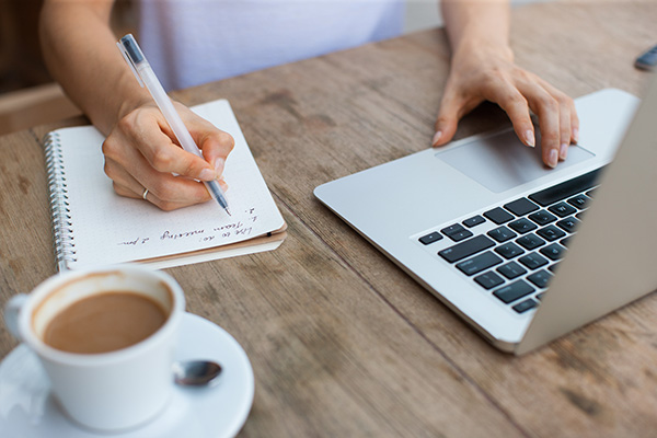 Woman writing shopping list on paper