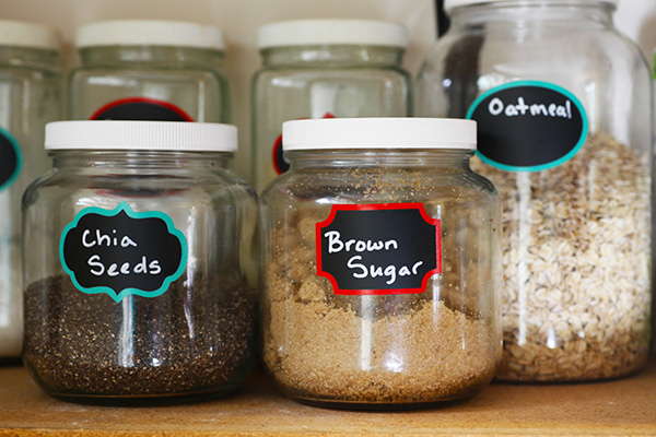 Glass jars filled with kitchen staples on pantry shelf.