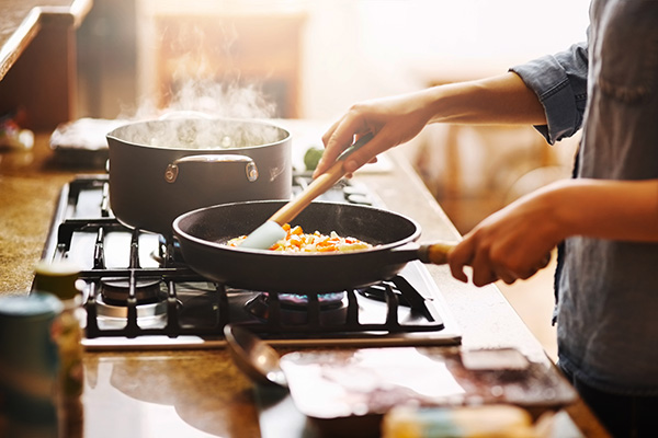 Woman stirring vegetables in a pan