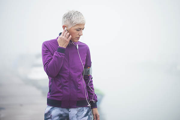 mature woman jogging through fog