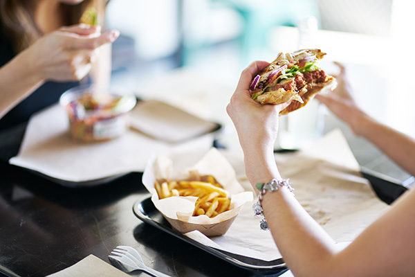 Woman eating a burger and fries